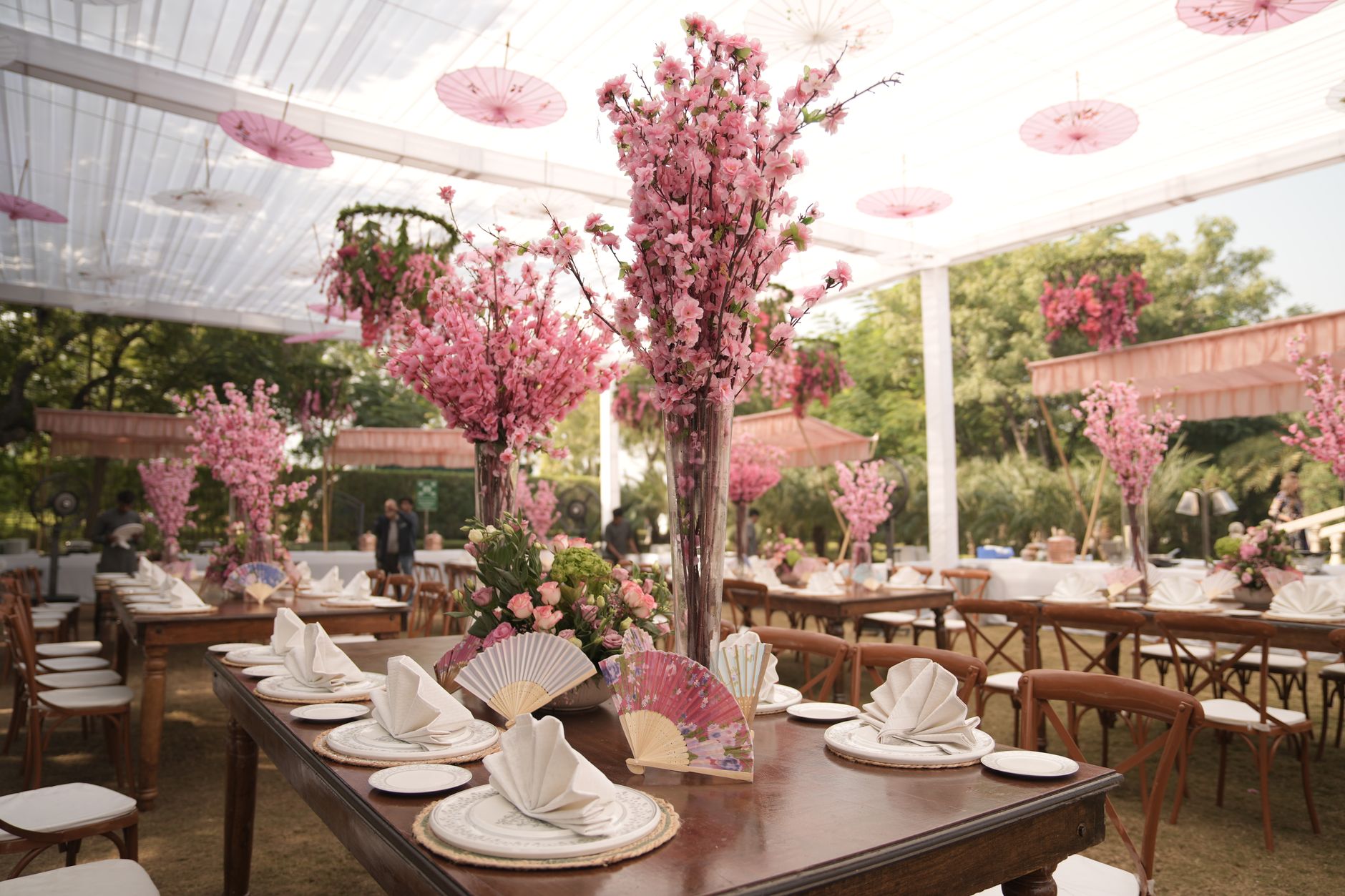 Stunning outdoor Indian wedding setup with pink floral decor and traditional fans. — Aqua Panels Provide a Durable Surface fo